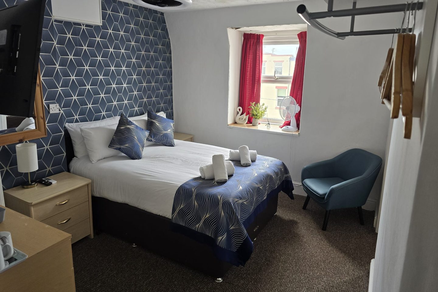 Family Suite double room with a patterned feature wall, armchair and hanging space