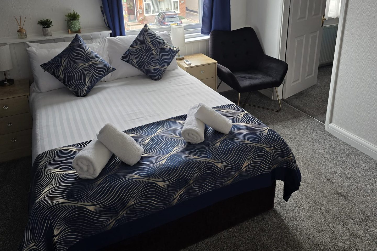Family Suite at The Cumbrian Hotel, Blackpool, with a double bed, bedside tables, armchair and the door through to the second room