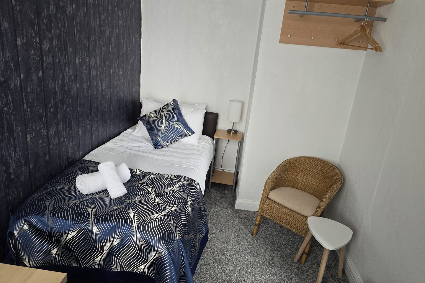 Single bed, chair and hanging rail in the second room of the Family Suite